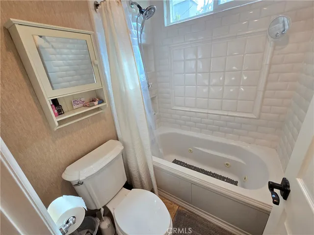 a white toilet sitting next to a bath tub