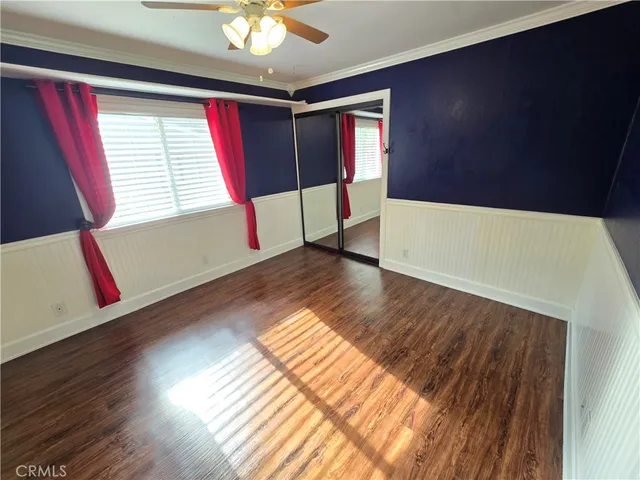 a view of an empty room with window and wooden floor