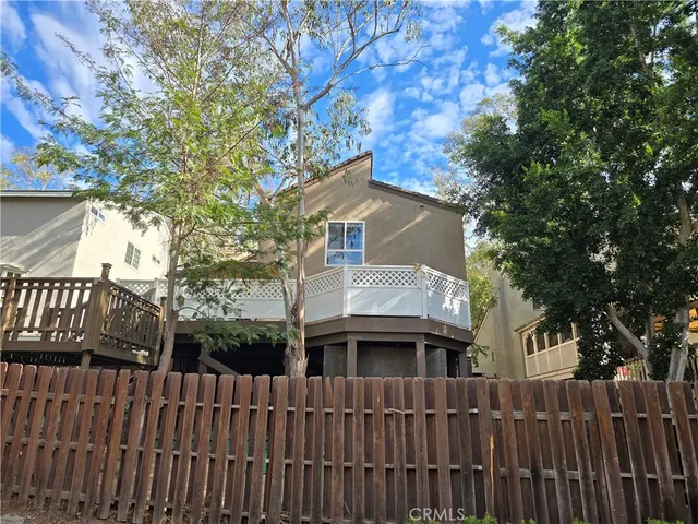 a brick house with large trees in front of it