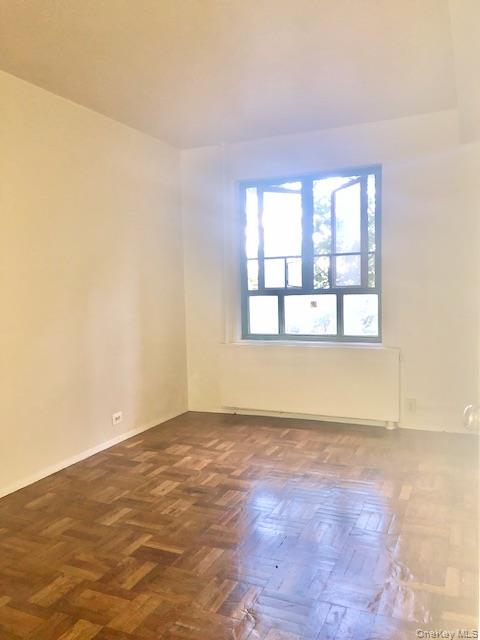 1565 Odell Street, Unit 1F Bronx, NY 10462 - Photo 2 of 10 an empty room with wooden floor and windows