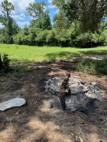 a view of a backyard with table and chairs and a garden
