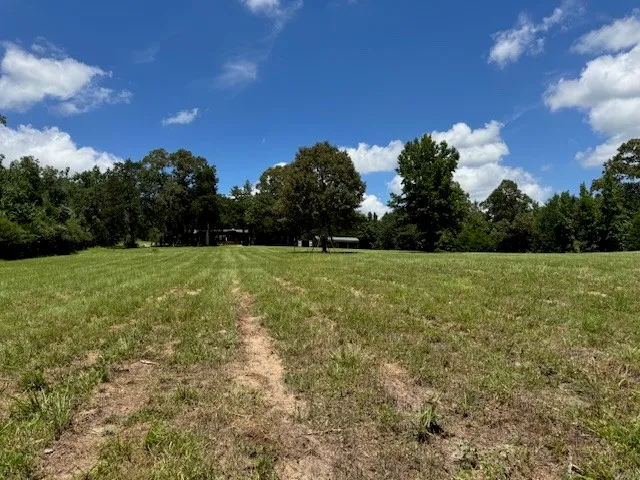 a view of a field with a house in the background