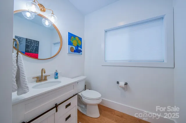 a bathroom with a toilet sink vanity and mirror
