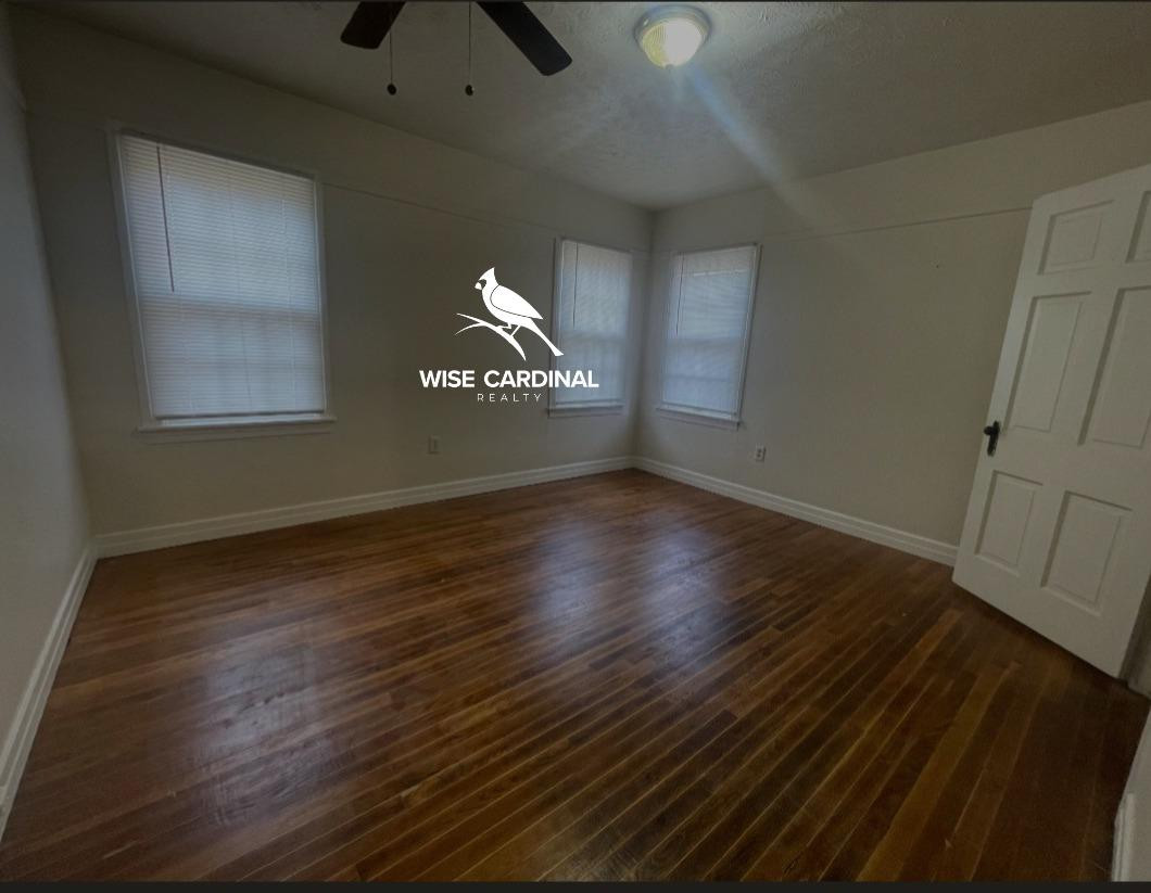 1726 25th Street Lubbock, TX 79411 - Photo 8 of 11 an empty room with wooden floor chandelier fan and windows