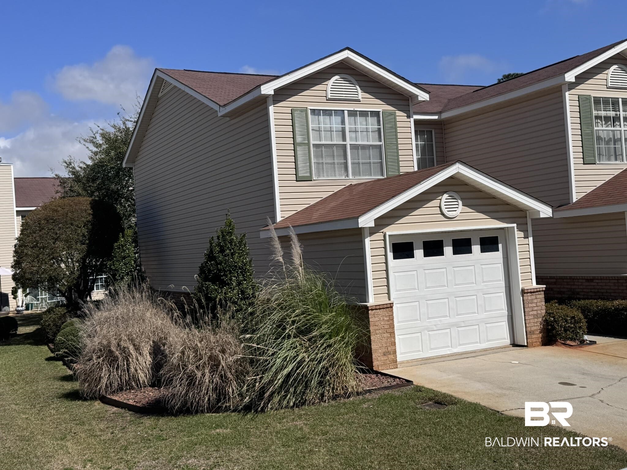 1517 Regency Road, Unit 131 Gulf Shores, AL 36542 - Photo 19 of 21 Traditional home with concrete driveway, an attached garage, a front yard, and a shingled roof