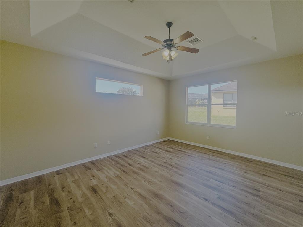 4940 Southwest 63rd Loop Ocala, FL 34474 - Photo 20 of 45 a view of an empty room with wooden floor and a window