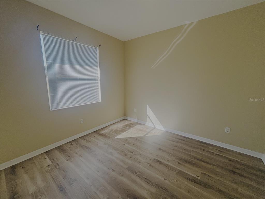 4940 Southwest 63rd Loop Ocala, FL 34474 - Photo 24 of 45 an empty room with a wooden floor and windows
