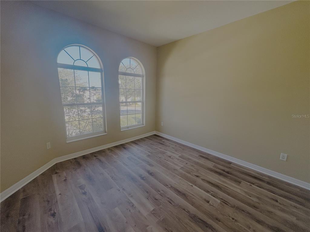 4940 Southwest 63rd Loop Ocala, FL 34474 - Photo 27 of 45 an empty room with wooden floor and windows