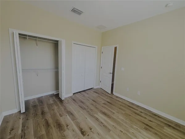 an empty room with wooden floor and closet