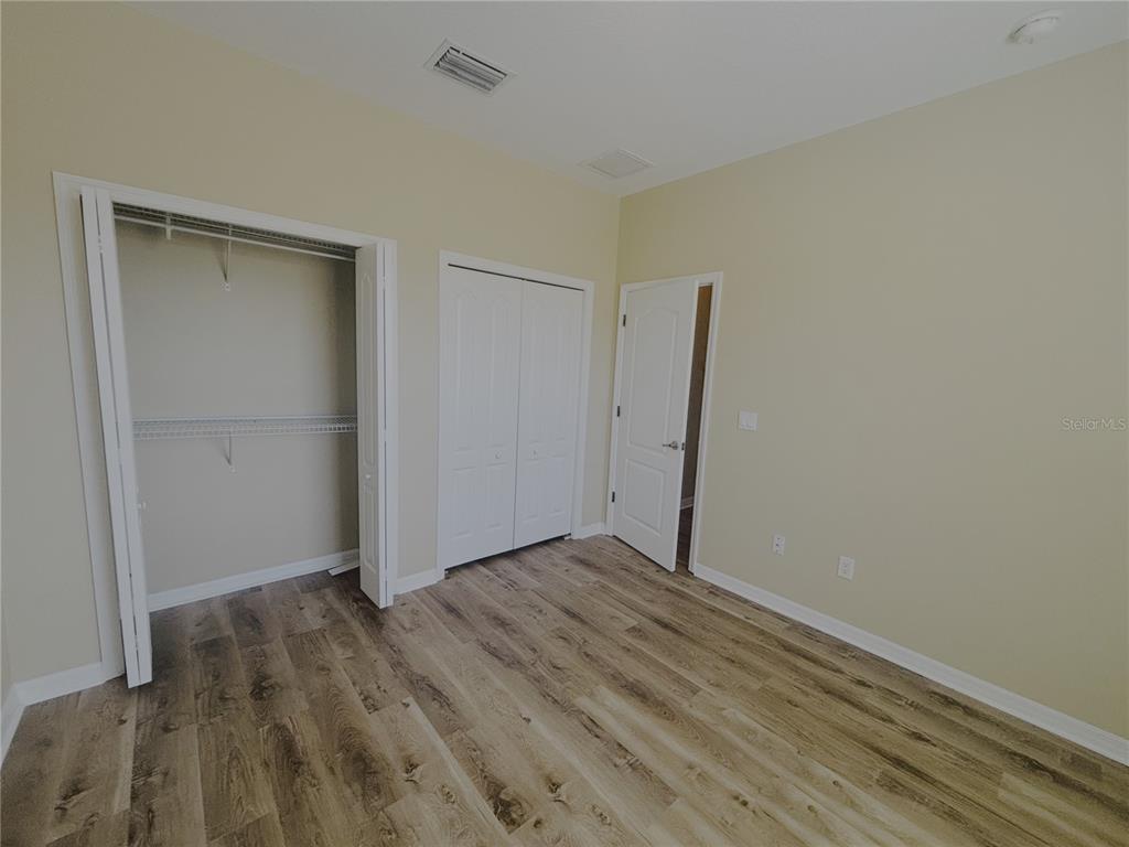 4940 Southwest 63rd Loop Ocala, FL 34474 - Photo 29 of 45 an empty room with wooden floor and closet