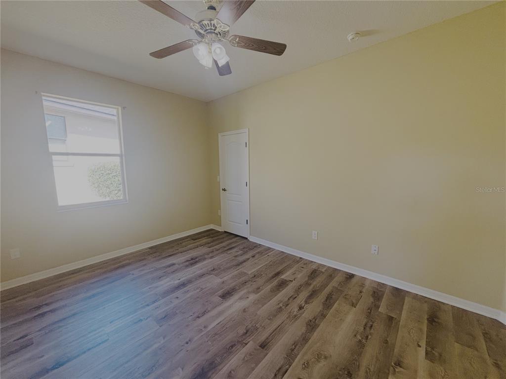 4940 Southwest 63rd Loop Ocala, FL 34474 - Photo 30 of 45 a view of an empty room with wooden floor and a window
