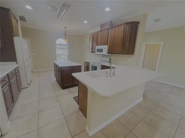 a kitchen with stainless steel appliances a sink a stove a microwave a counter top space and cabinets