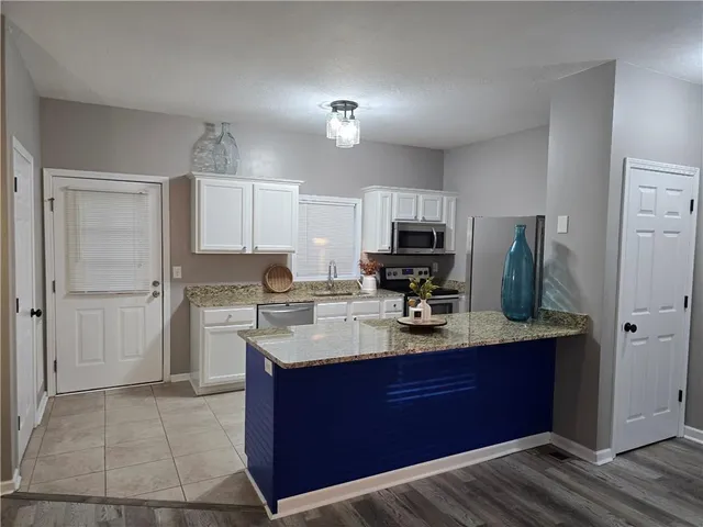 a kitchen with a refrigerator sink and cabinets