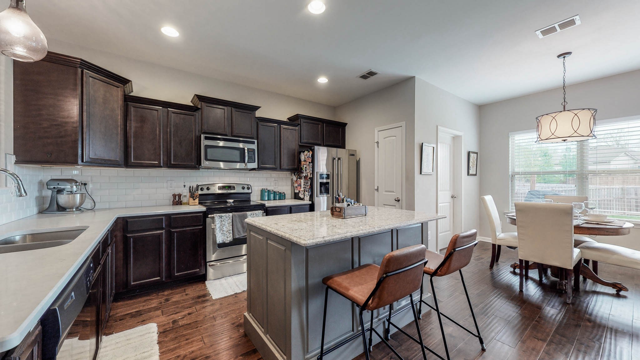 1115 Golf View Way Spring Hill, TN 37174 - Photo 7 of 49 a kitchen with stainless steel appliances granite countertop a stove top oven a sink dishwasher a dining table and chairs