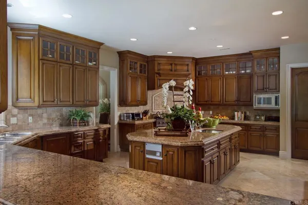 a kitchen with kitchen island granite countertop a sink stove and refrigerator