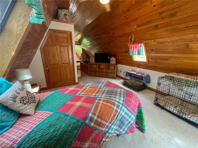 a bed sitting in a bedroom next to a window with pc on the table