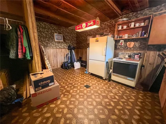 a storage room with water heater and a refrigerator