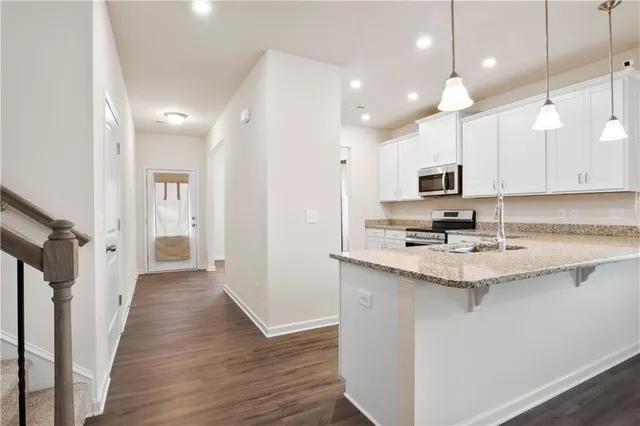 a kitchen with kitchen island granite countertop a sink appliances cabinets and a counter top space