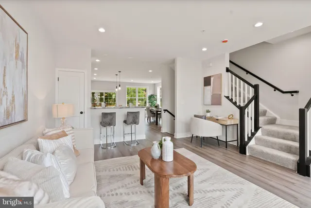 a living room with furniture and a dining table with wooden floor