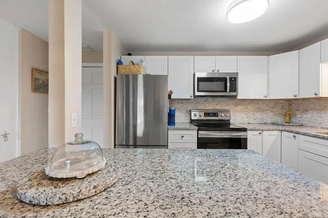 a kitchen with granite countertop a stove and a microwave