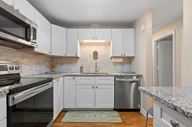 a kitchen with stainless steel appliances granite countertop a stove sink and microwave
