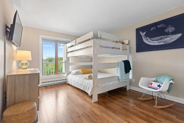 a spacious bedroom with a bed and wooden floor