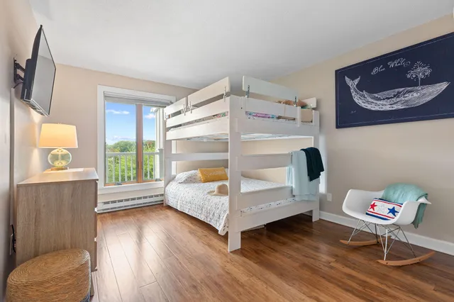 a spacious bedroom with a bed and wooden floor