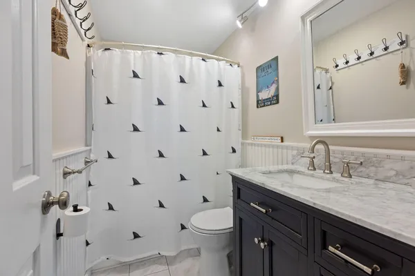 a bathroom with a granite countertop sink a toilet and a shower