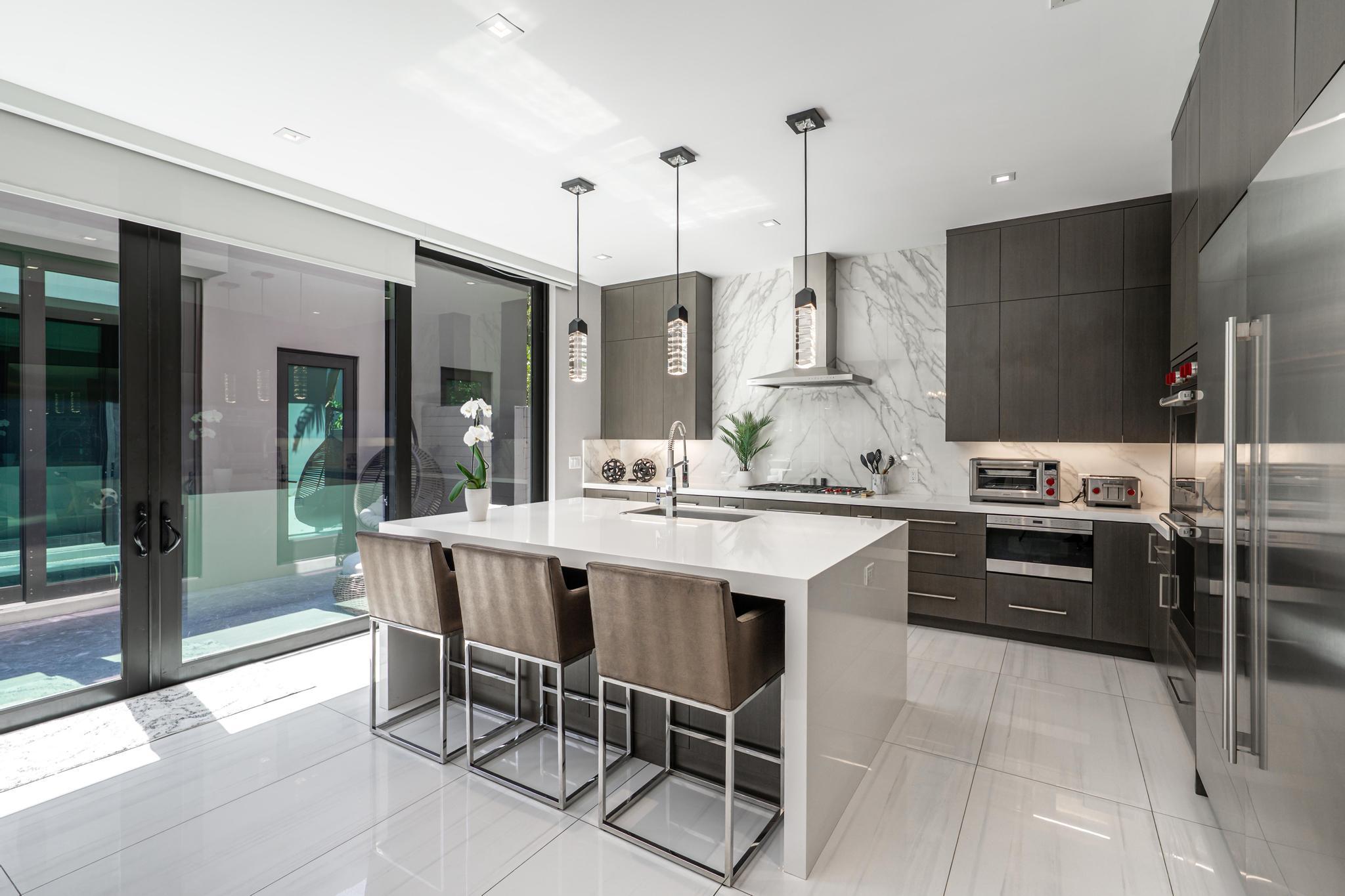 520 Northeast 4th Lane Boca Raton, FL 33432 - Photo 16 of 40 a kitchen with stainless steel appliances a table and chairs in it