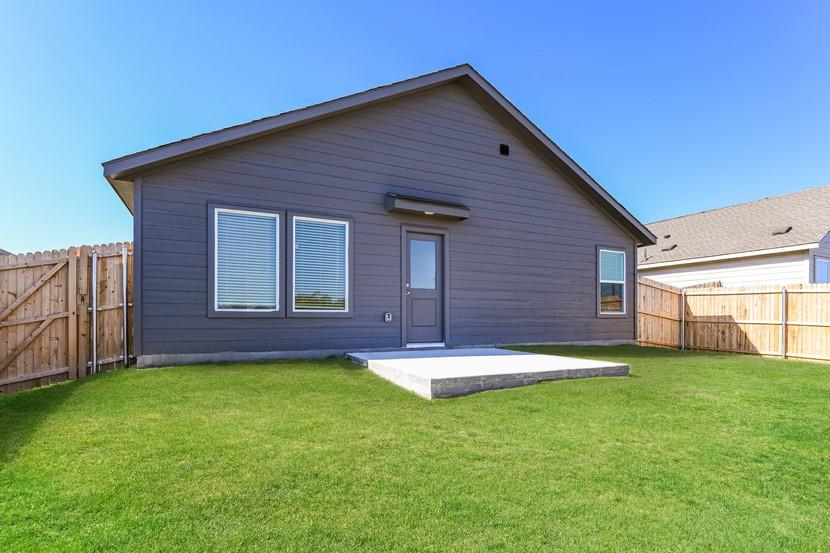 2713 Ctr Crk Lane Fort Worth, TX 76108 - Photo 5 of 5 Rear exterior featuring gray siding, a concrete patio, and a fully fenced yard with a wooden privacy fence