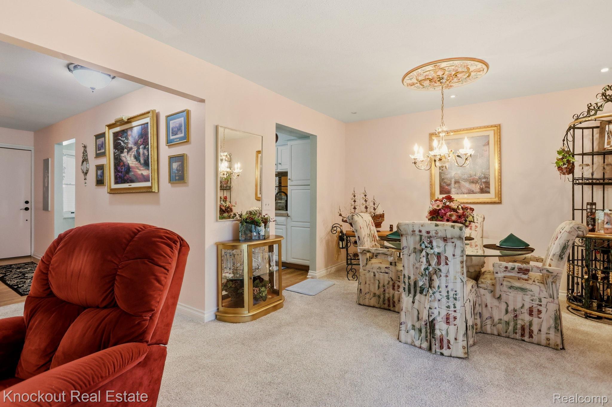 249 Churchgrove Road Frankenmuth, MI 48734 - Photo 11 of 44 Dining area featuring a glass-top table, upholstered chairs, and a chandelier with a decorative ceiling medallion