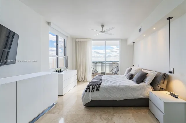 a bedroom with a bed and a large window