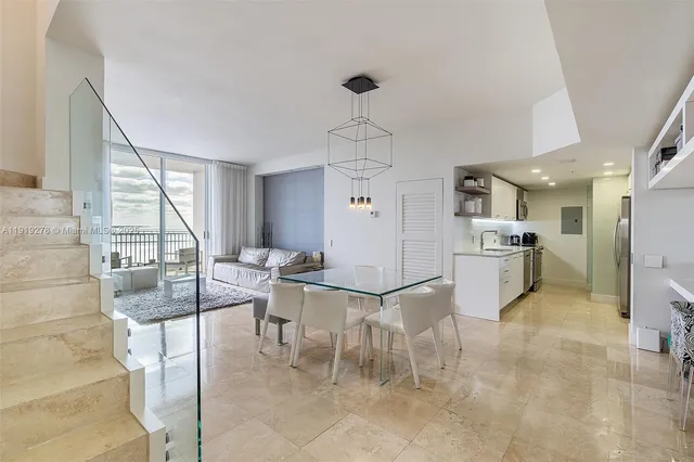 a living room with couches a dining table and chairs with kitchen view