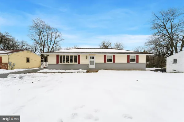 a front view of a house with a yard covered in snow
