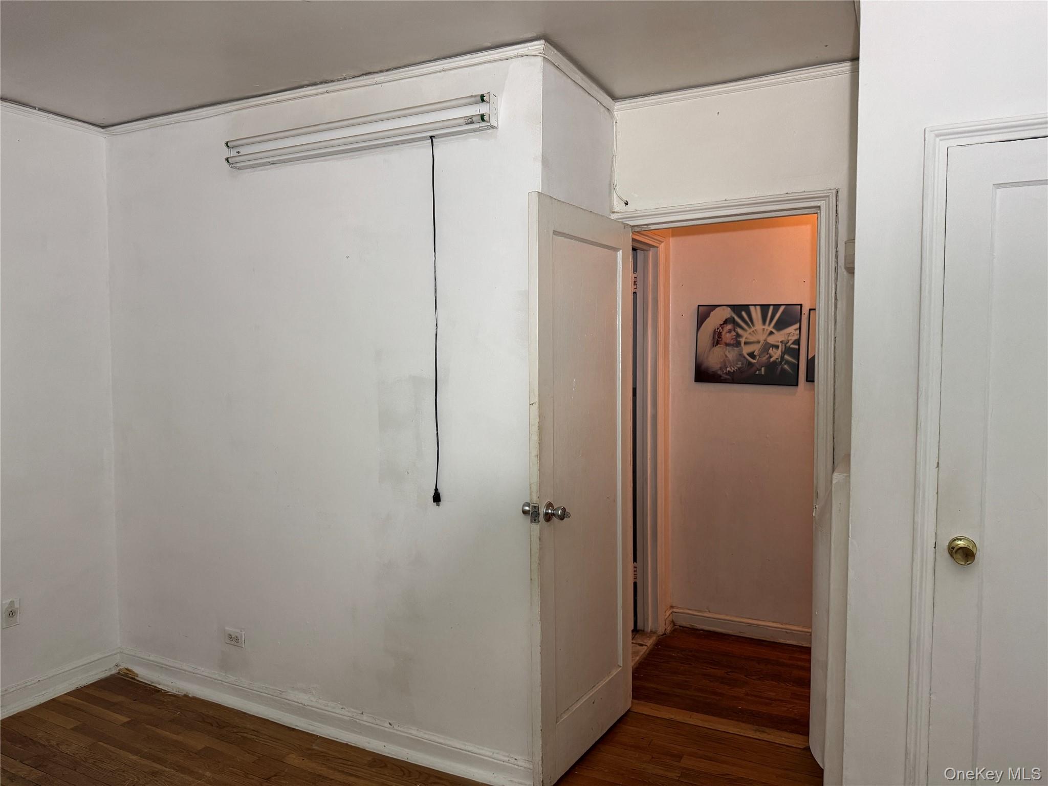 Hall featuring dark wood-style flooring and baseboards