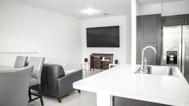a kitchen with a table chairs and flat screen tv