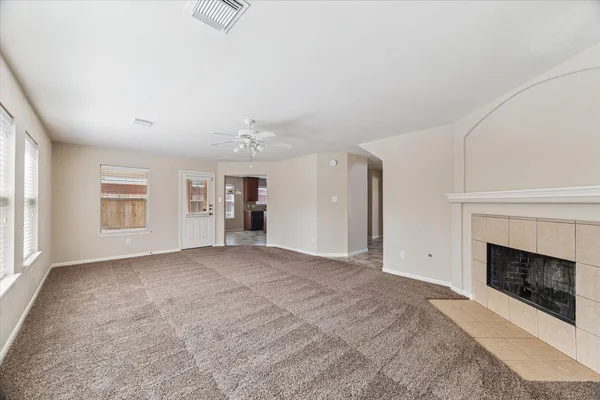 a view of an empty room with a fireplace and a window