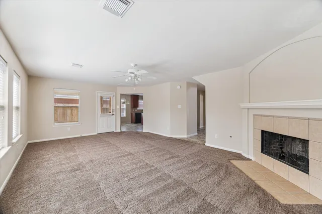 a view of an empty room with a fireplace and a window