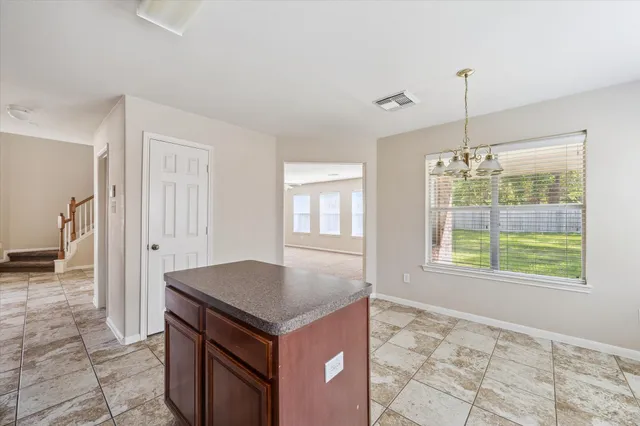 a kitchen with kitchen island a counter top space appliances and a chandelier