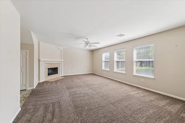 a view of an empty room with a fireplace and a window