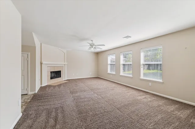 a view of an empty room with a fireplace and a window