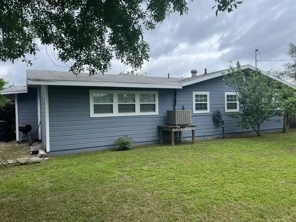a backyard of a house with table and chairs