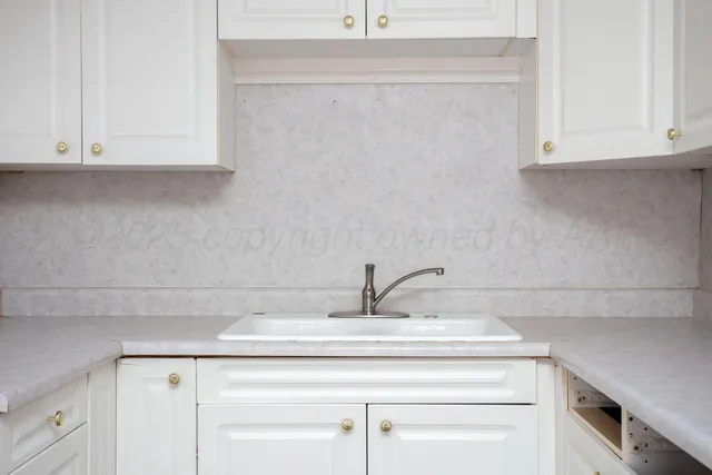 a sink with white cabinets