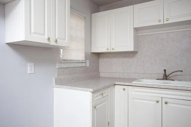 a kitchen with stainless steel appliances granite countertop a sink and a white cabinets