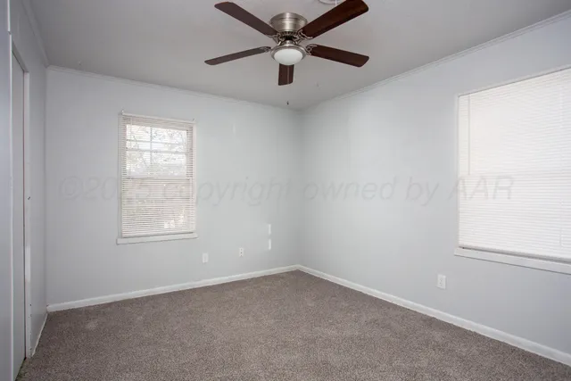 an empty room with a window and a fan