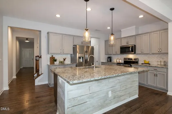 a kitchen with stainless steel appliances granite countertop a sink refrigerator and cabinets
