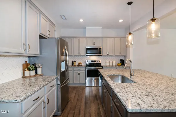 a kitchen with stainless steel appliances granite countertop a sink stove and refrigerator