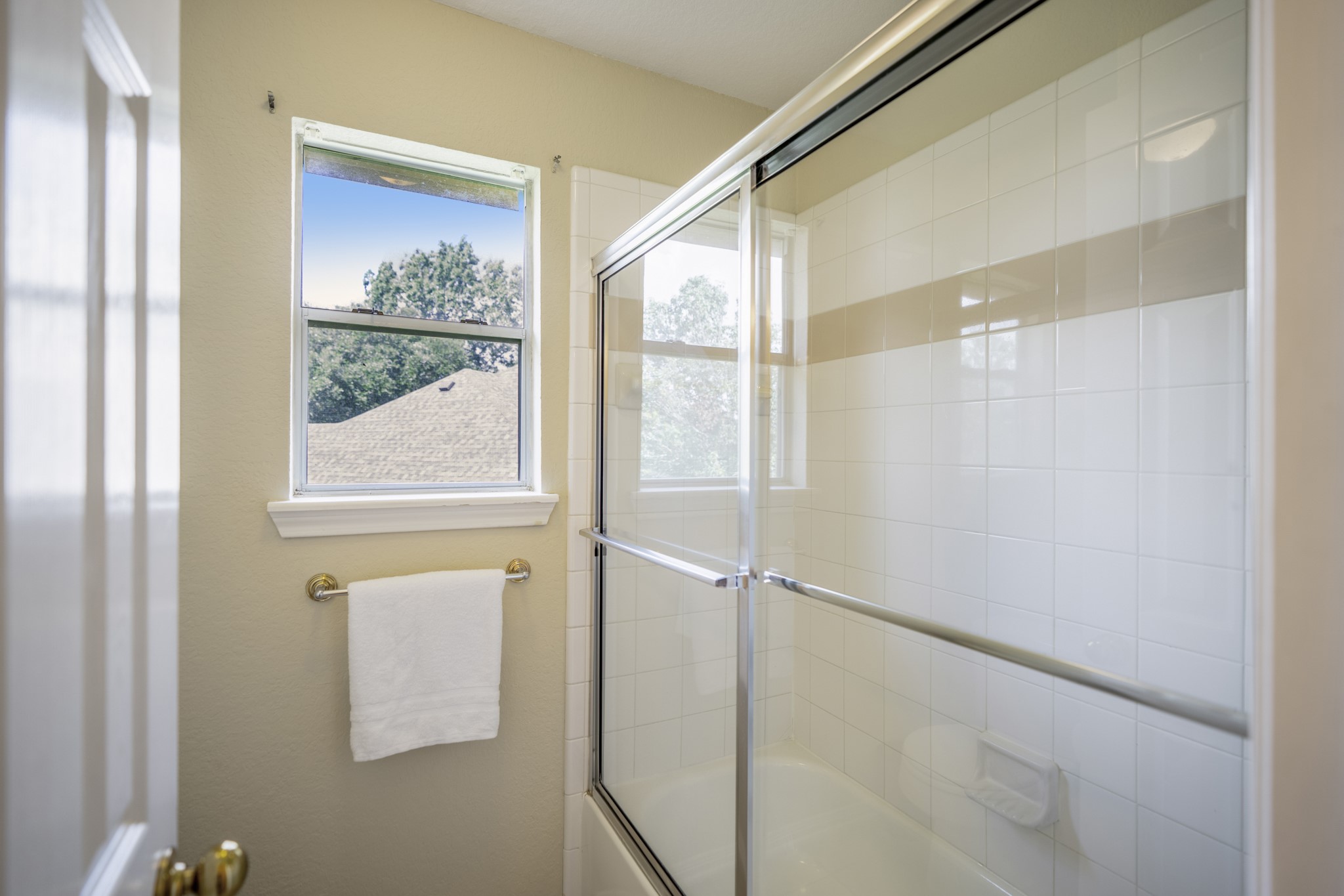 5807 Sequoia Trace Court Spring, TX 77379 - Photo 29 of 50 The separate bath area includes a tub/shower combination with a sliding glass enclosure and a window that brings natural light into the space.