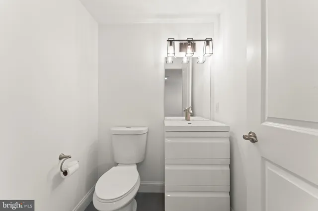 a bathroom with a toilet a sink and mirror