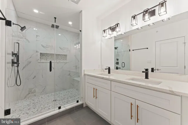 a bathroom with a double vanity sink mirror and shower